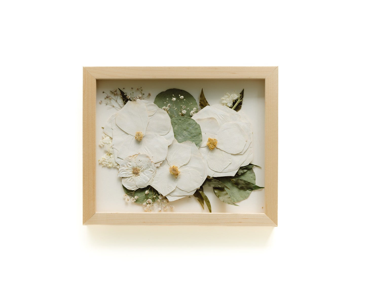 Framed artwork with white flowers and green leaves on a white background